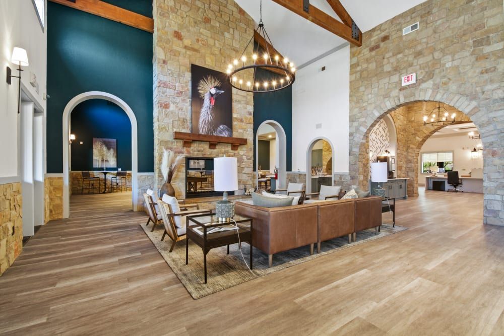 a large clubhouse room filled with furniture and a fireplace at Marquis on Evans in San Antonio, TX.