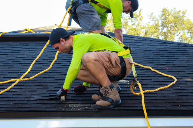 An image of roofing contractors replacing asphalt shingles on local residential roof repair project in Ocoee FL