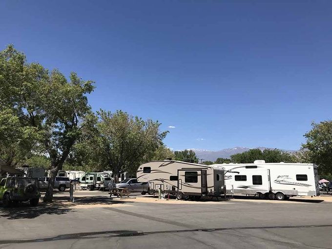 A group of rvs are parked in a parking lot.