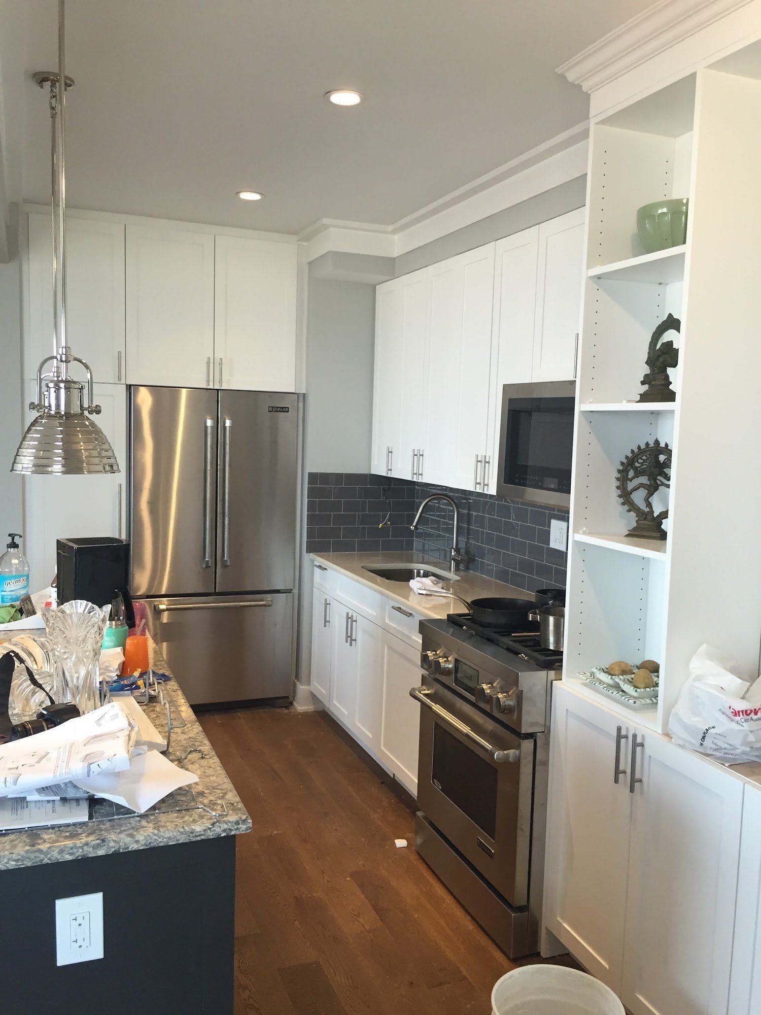 A kitchen with stainless steel appliances and white cabinets