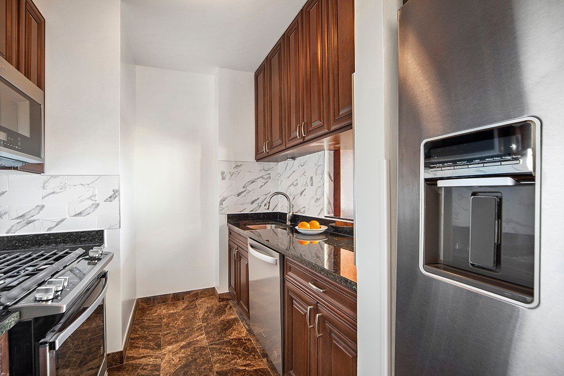 A kitchen with stainless steel appliances and wooden cabinets.