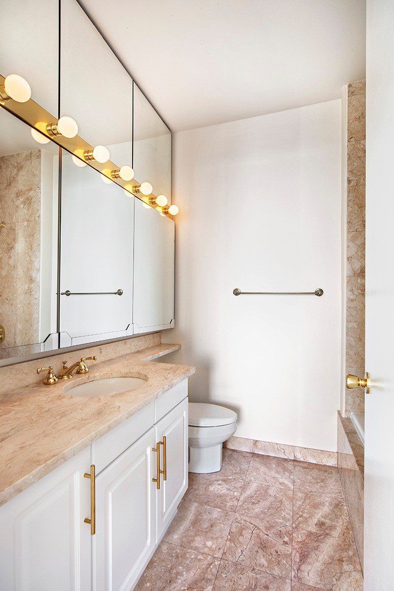 A bathroom with a sink , toilet , and mirror.