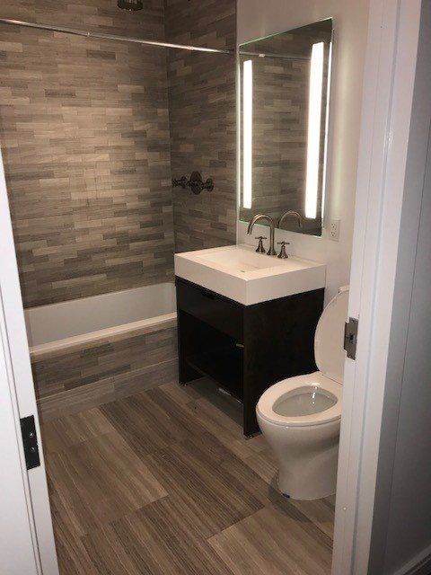 A bathroom with a toilet a sink and a bathtub