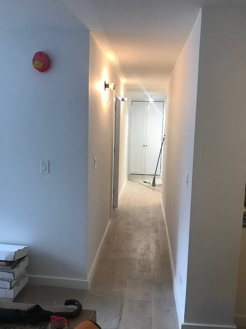 A long hallway with white walls and a red ball on the wall