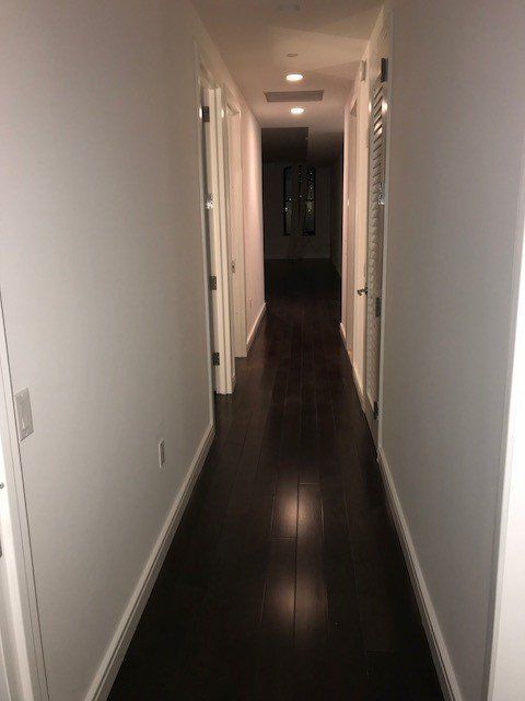 A long hallway with hardwood floors and white walls