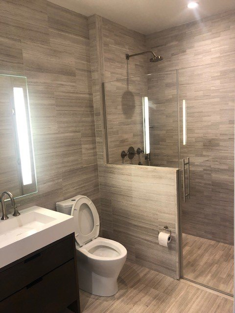 A bathroom with a toilet , sink and shower