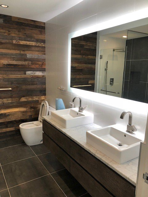 A bathroom with two sinks and a toilet