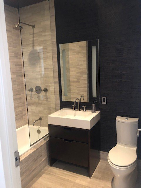 A bathroom with a sink toilet and bathtub