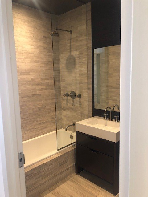 A bathroom with a sink a bathtub and a mirror