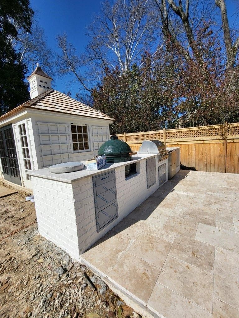 There is a large green egg grill in the backyard.