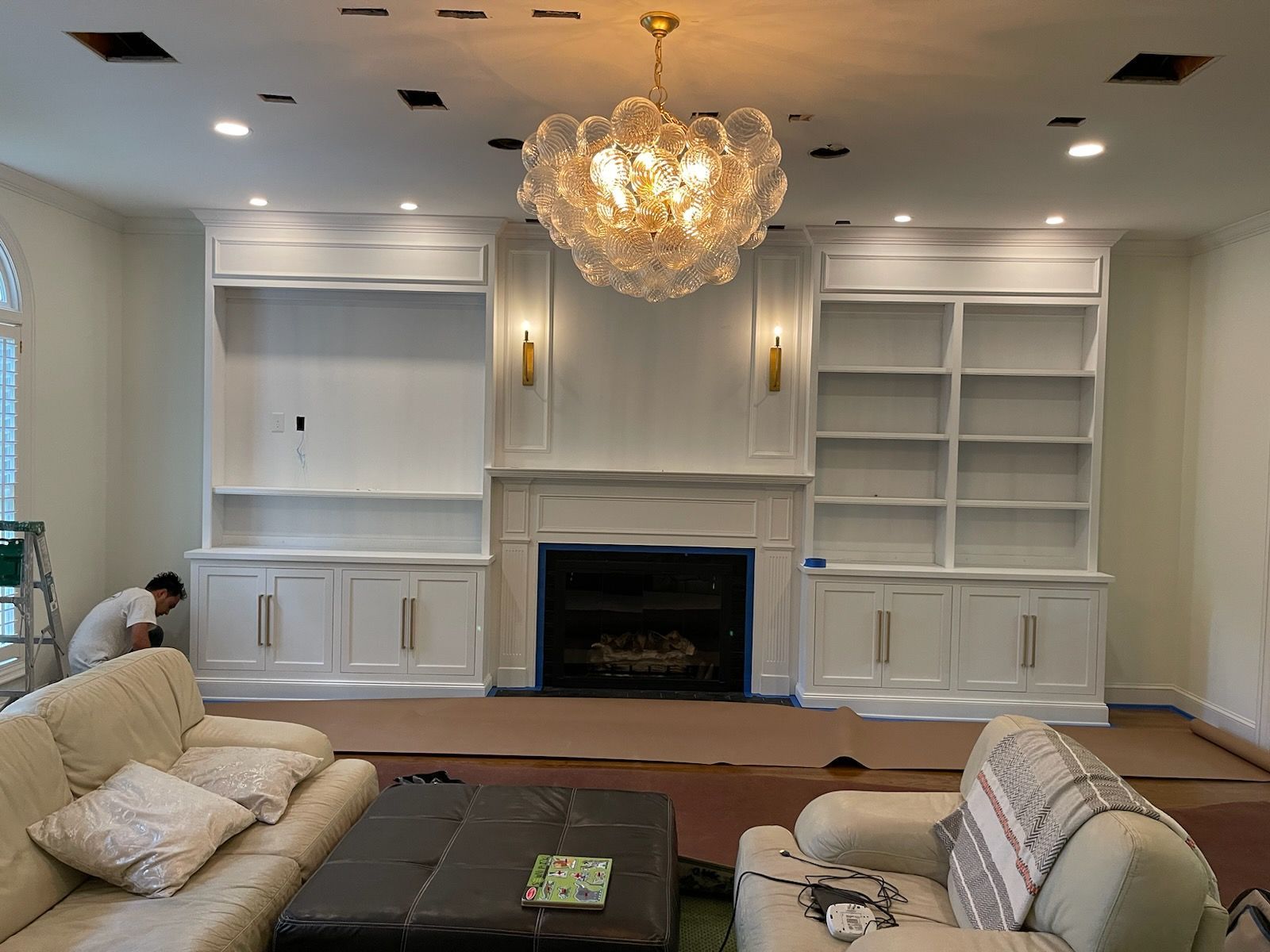 A living room with a fireplace and a chandelier.