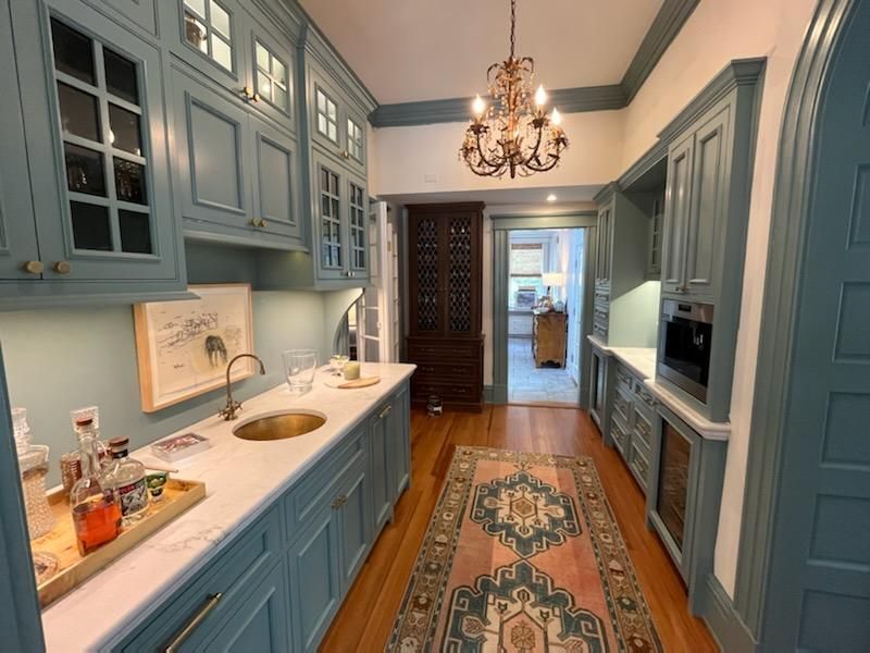 A kitchen with blue cabinets and a rug on the floor