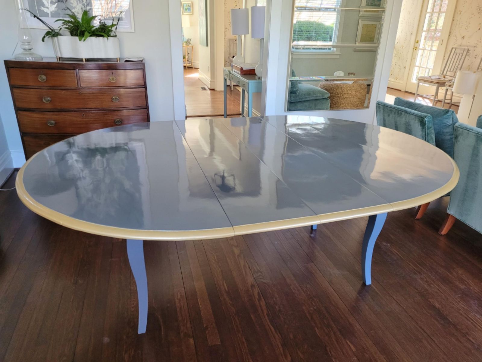A large oval table is sitting on a wooden floor in a living room.