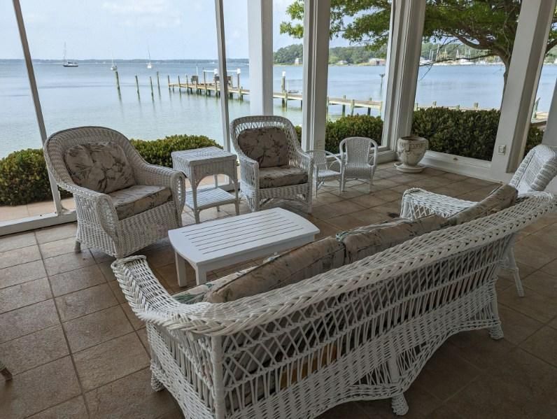 A living room with wicker furniture and a view of the ocean