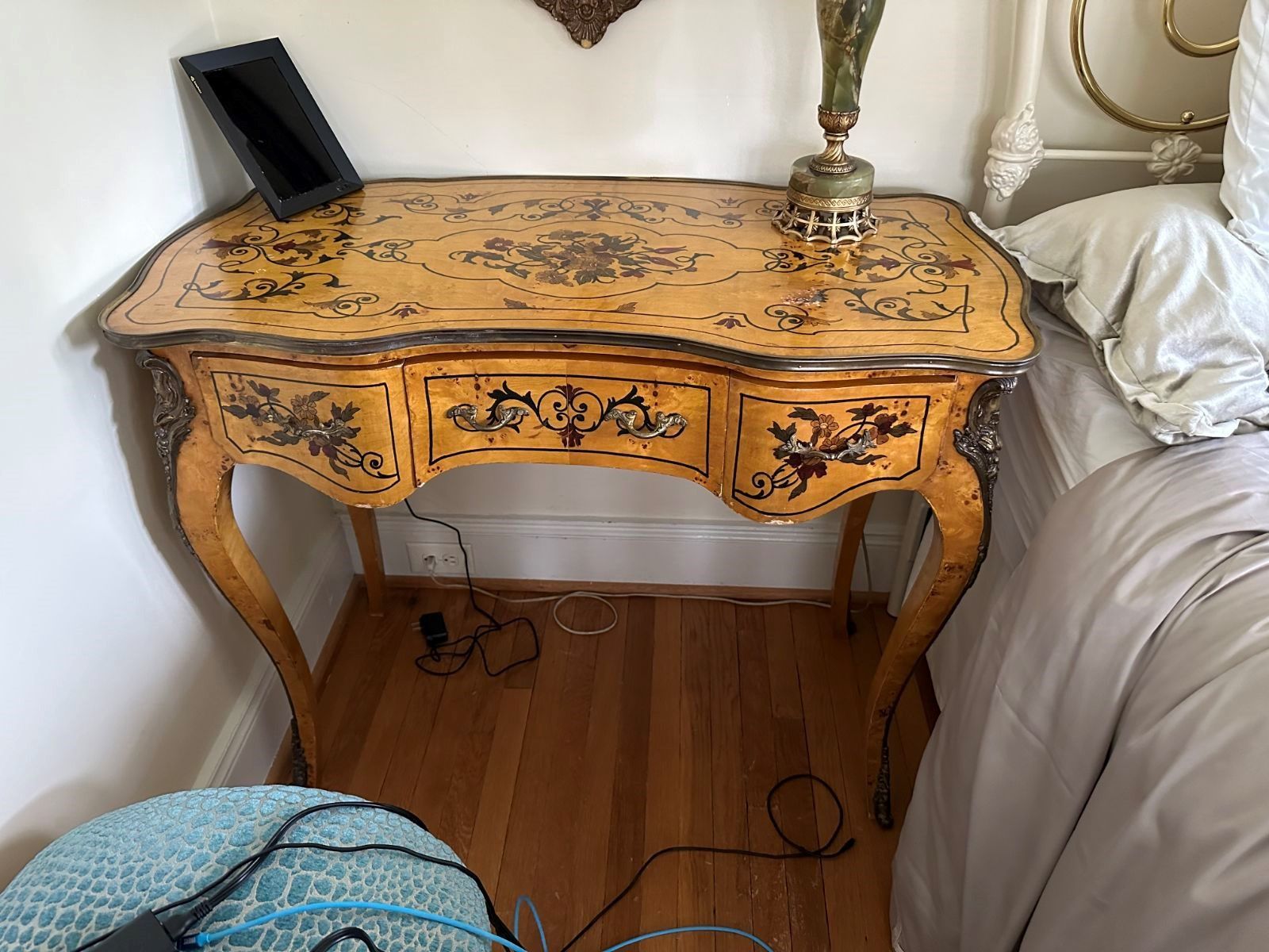 A small table in a bedroom next to a bed