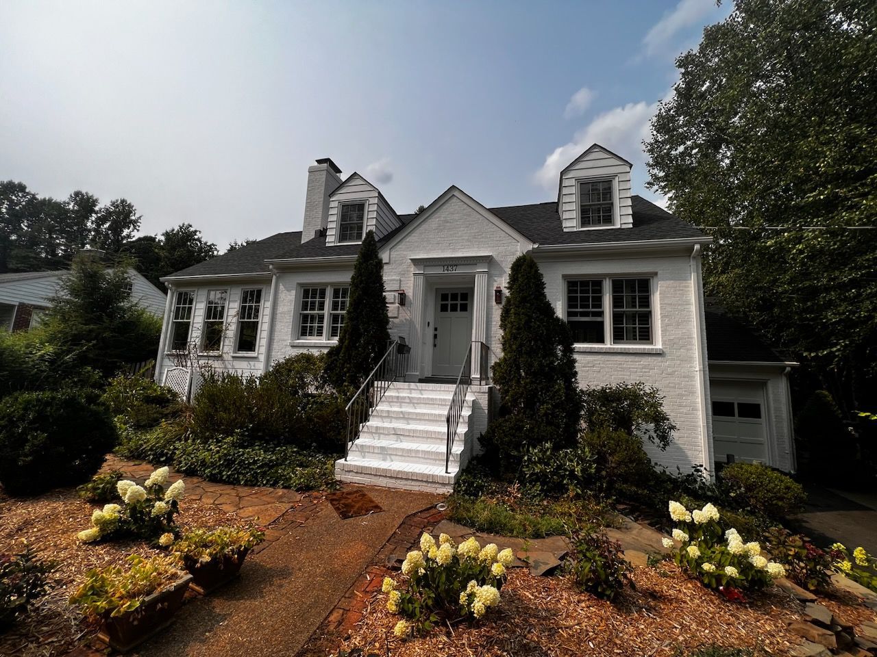 A white house with stairs leading up to the front door