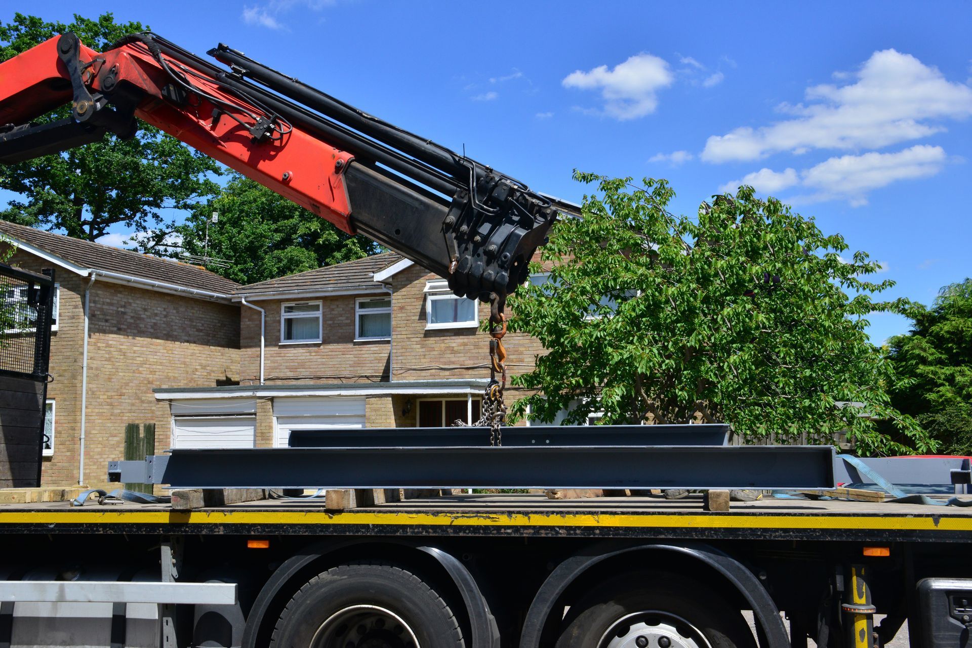 A large yellow truck is driving down a dirt road.