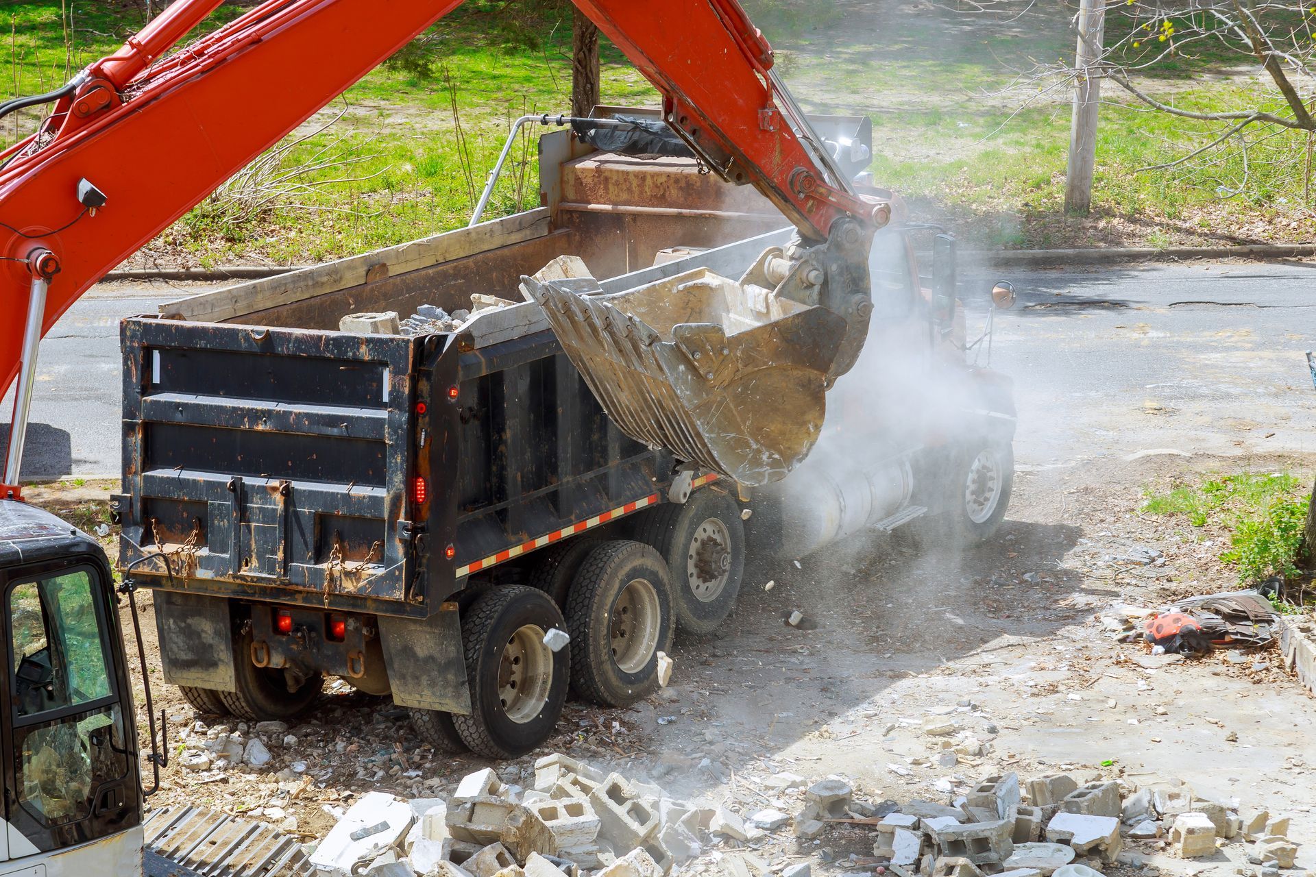 Excavator scoop truck loading construction waste into a dump truck Excavator scoop truck loading construction waste into a dump truck