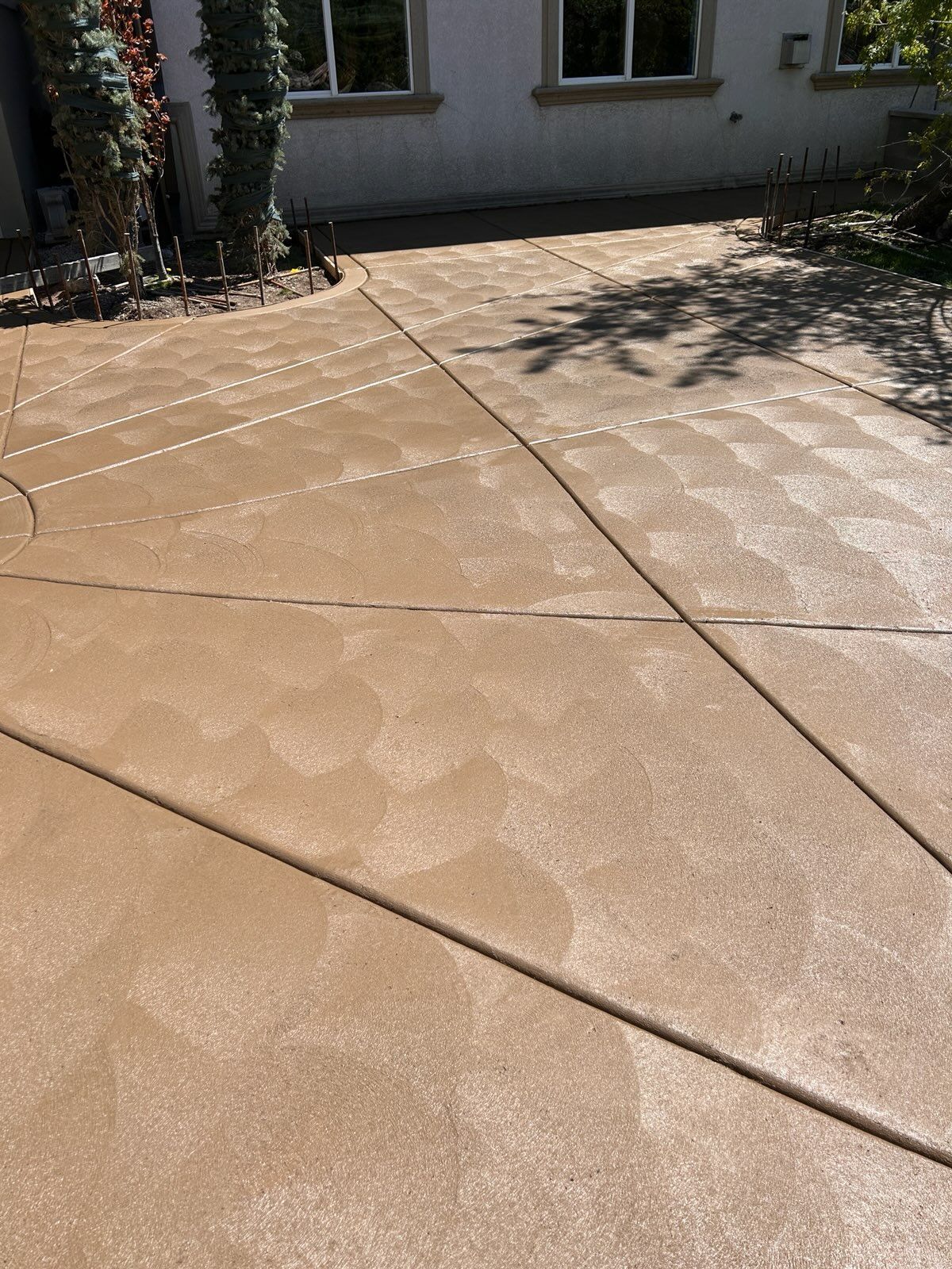 Woman in straw hat smiles, holding wine glass near a lake.