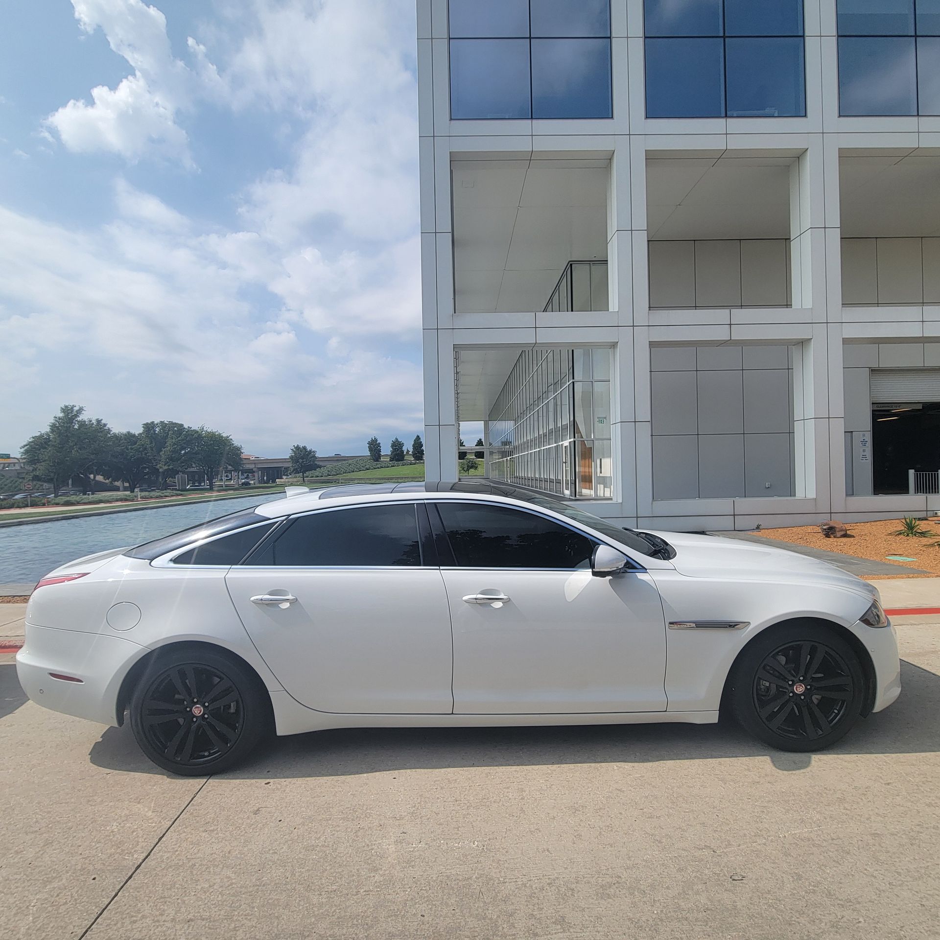 A white car is parked in front of a building