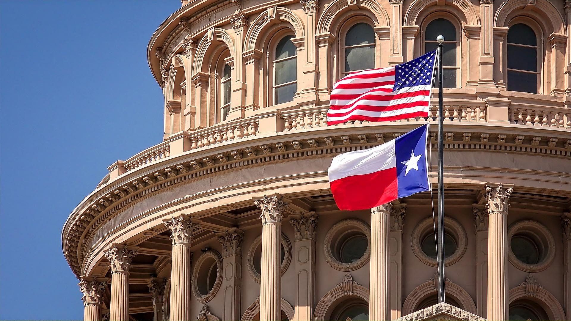 large building next to texas and american flags