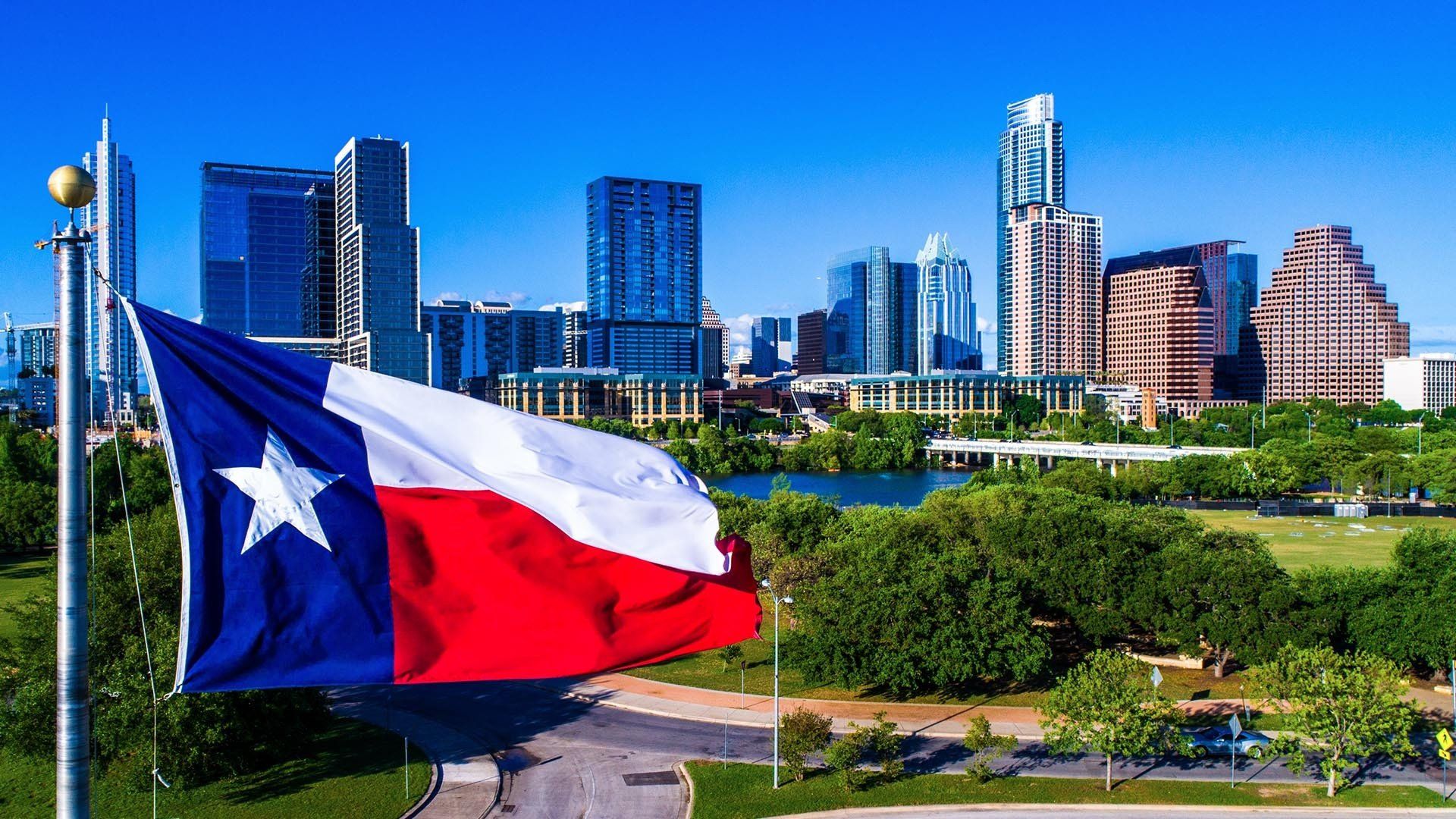 texas flag in front of a city skyline