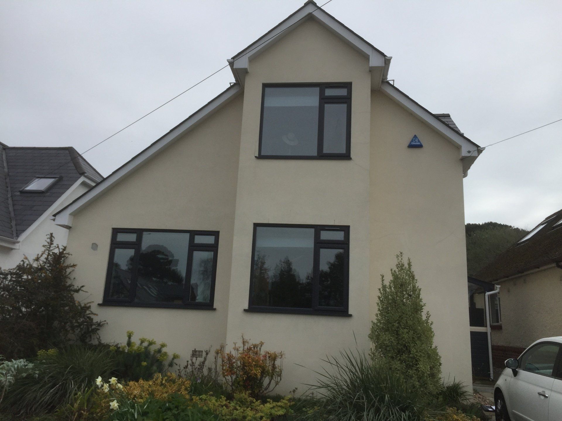finished new cream coloured rendering on home with black window frames