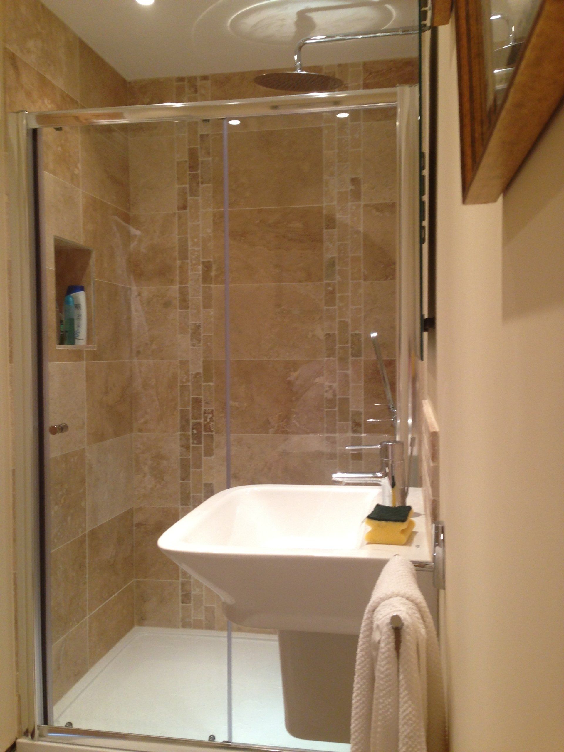 new round waterfall shower with pale brown tiled wall