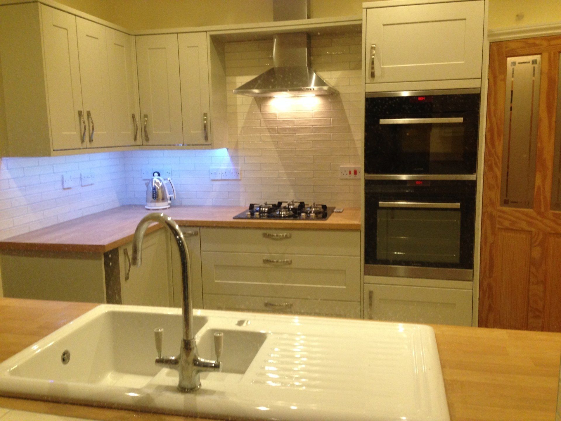 new kitchen with white metro tiles and eye level built in dual ovens