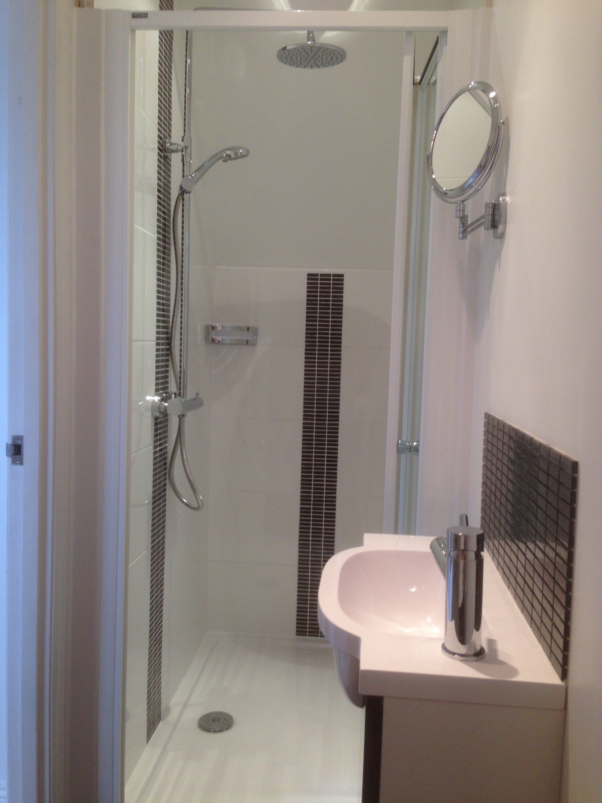 new galley style bathroom with shower and sink