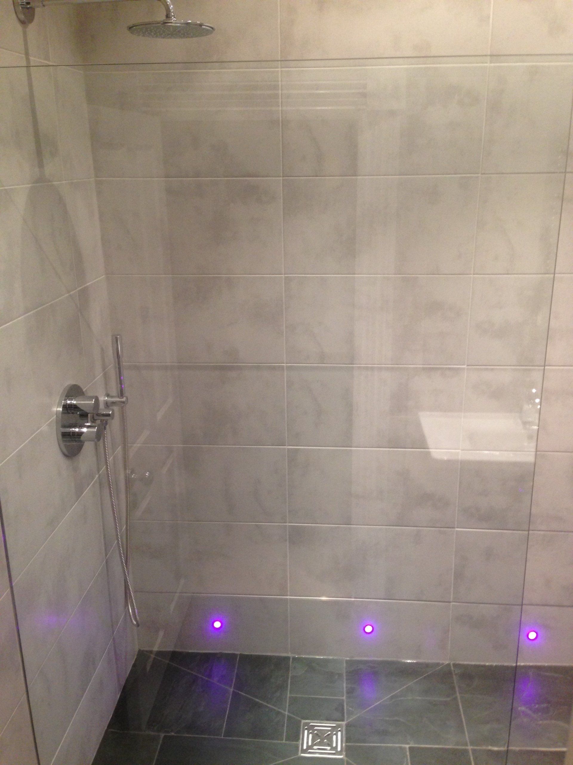 brand new rainfall shower with large marble effect grey tiles on wall