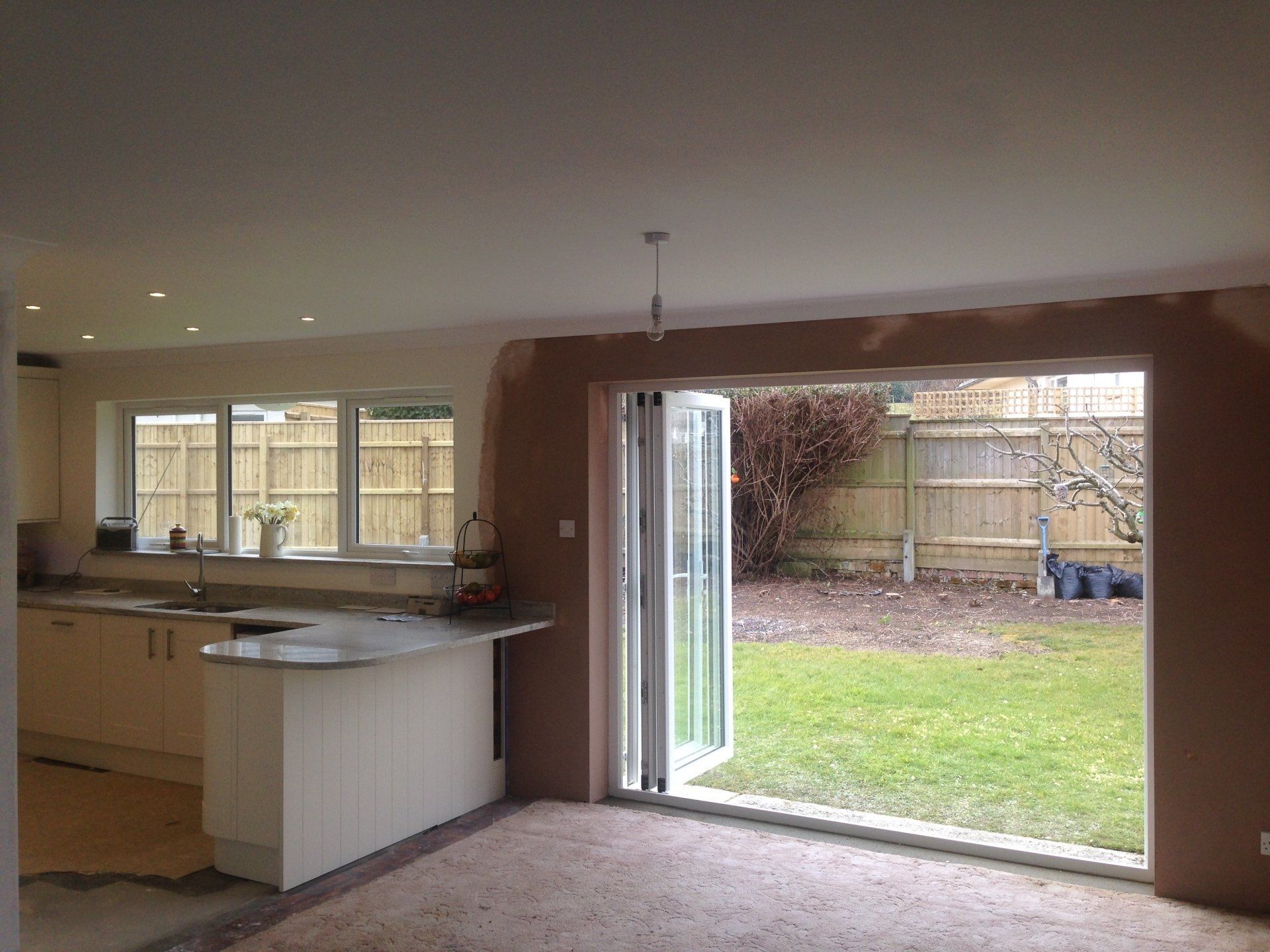 large doors open from new kitchen onto garden