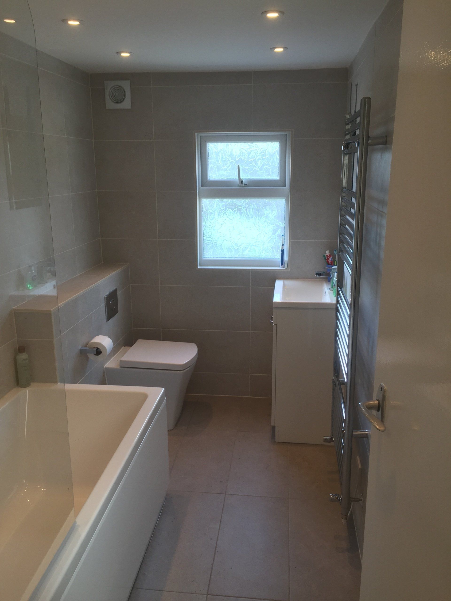 smart new bathroom with large pale grey tiles