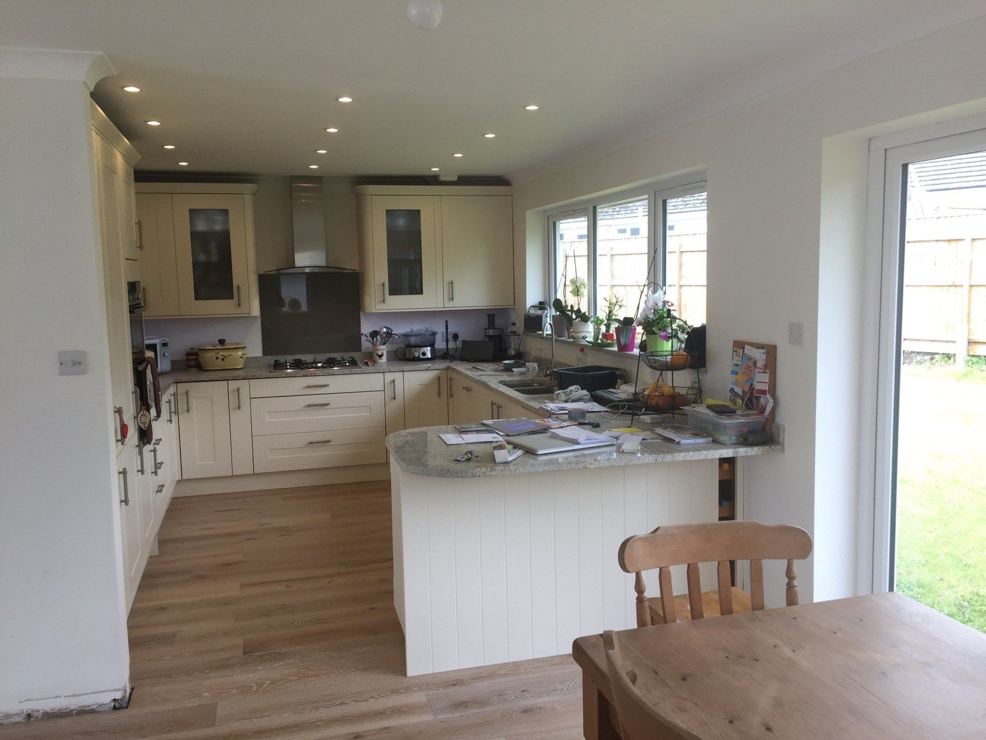 big new cream shaker style kitchen with grey marble worktops with wood effect flooring
