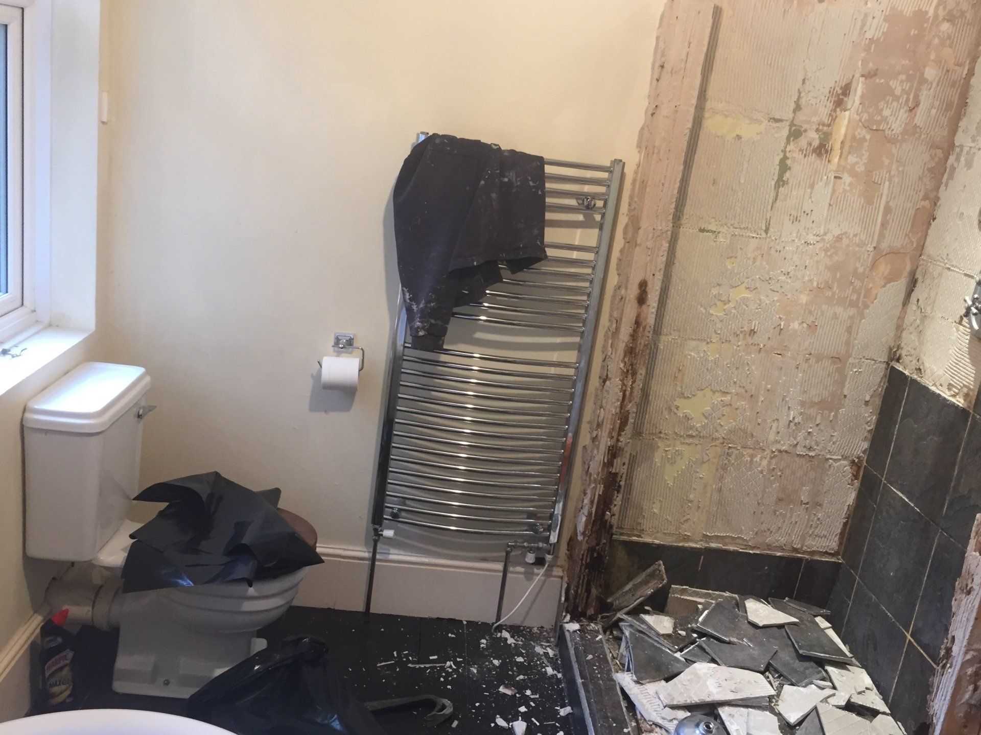 heated towel rail and tiles being taken off wall
