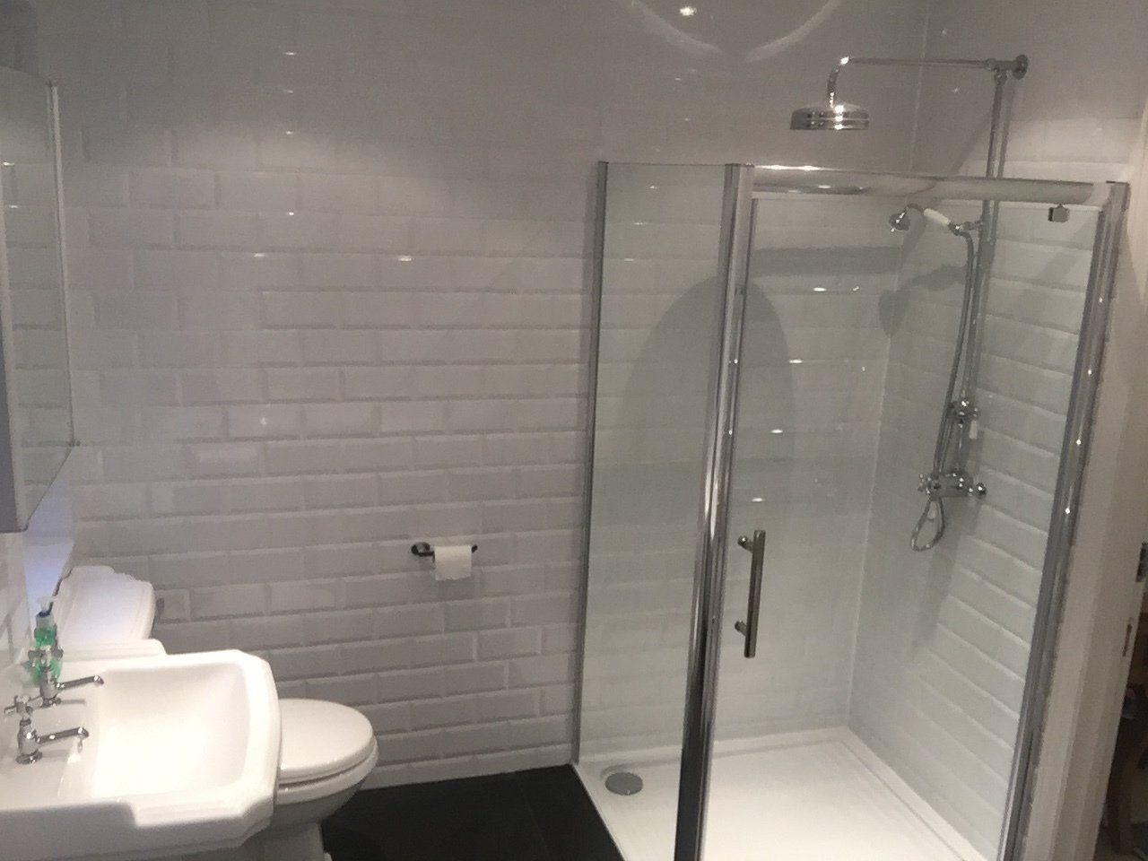 new white bathroom with rainfall shower in cubicle