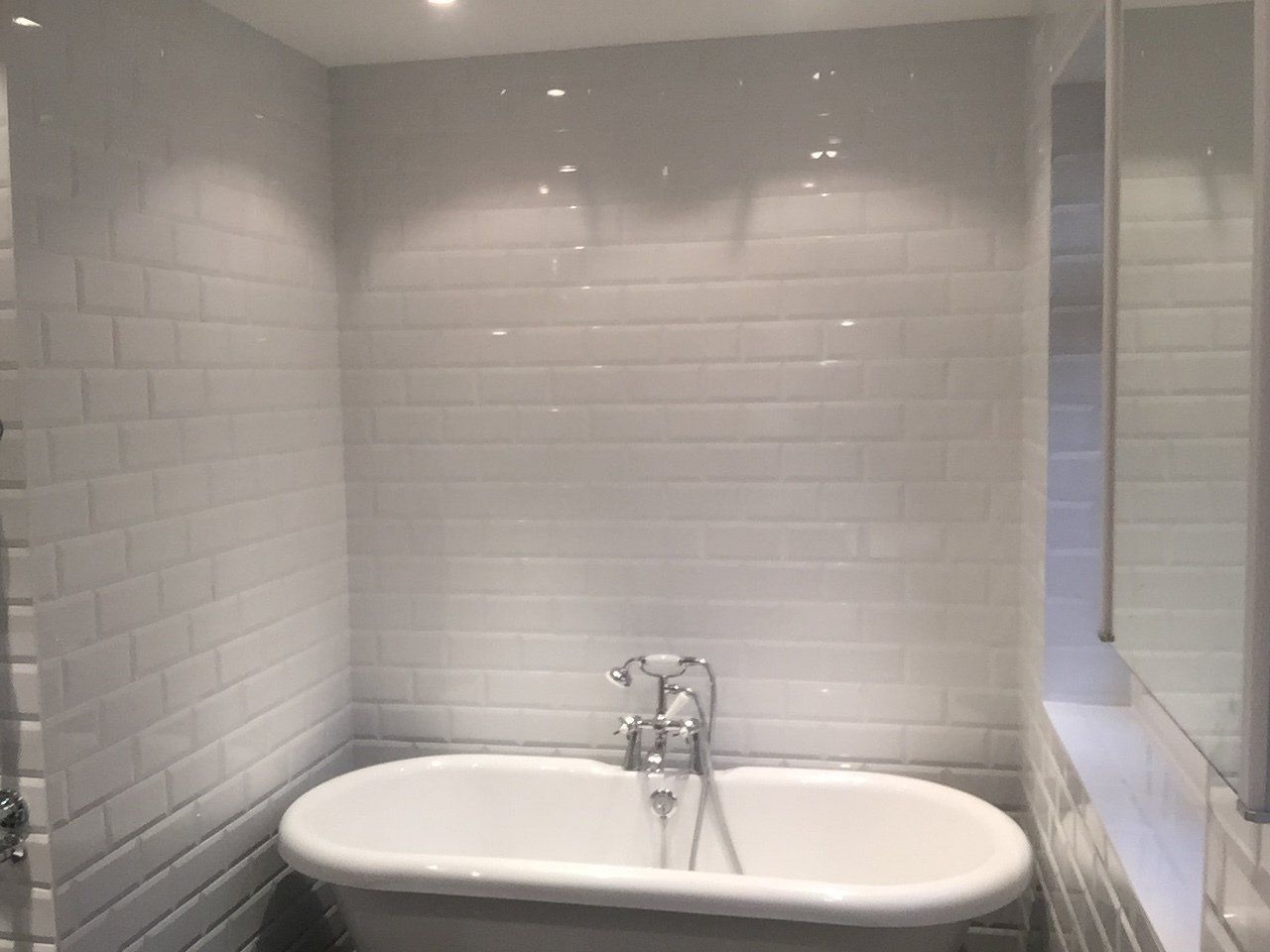 new white bathroom with rolltop bath
