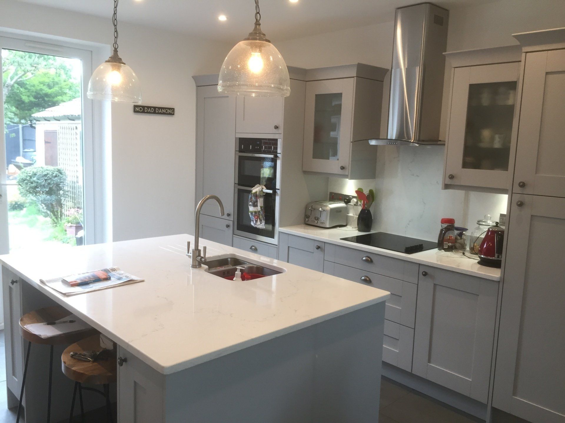 new gray shaker style kitchen with white marble work surface and island