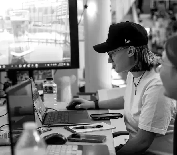 A woman is sitting at a desk using a laptop computer.