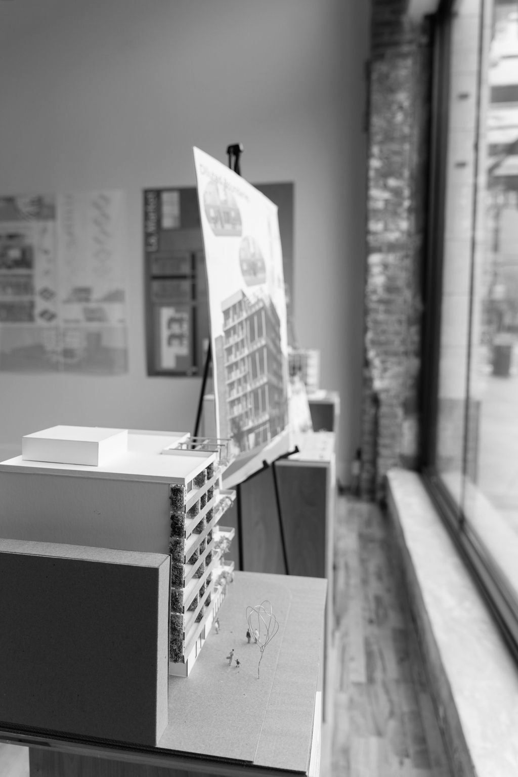 A black and white photo of a model of a building on a table.