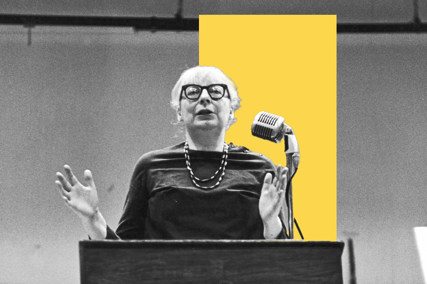 Jane Jacobs standing at a podium giving a speech.