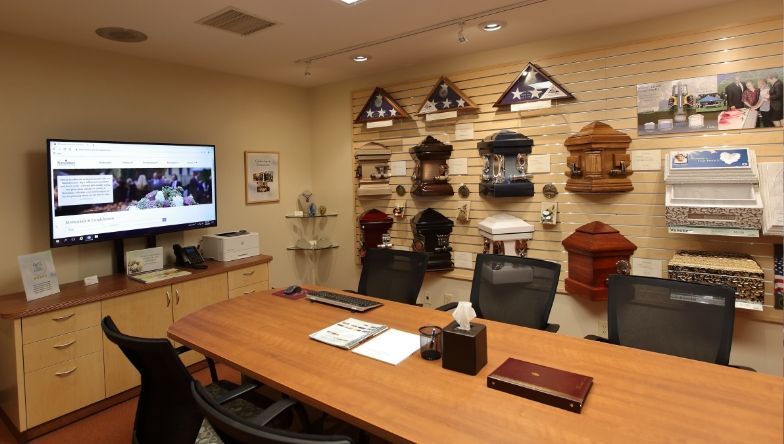 a conference room with a large wooden table and chairs and a flat screen tv .