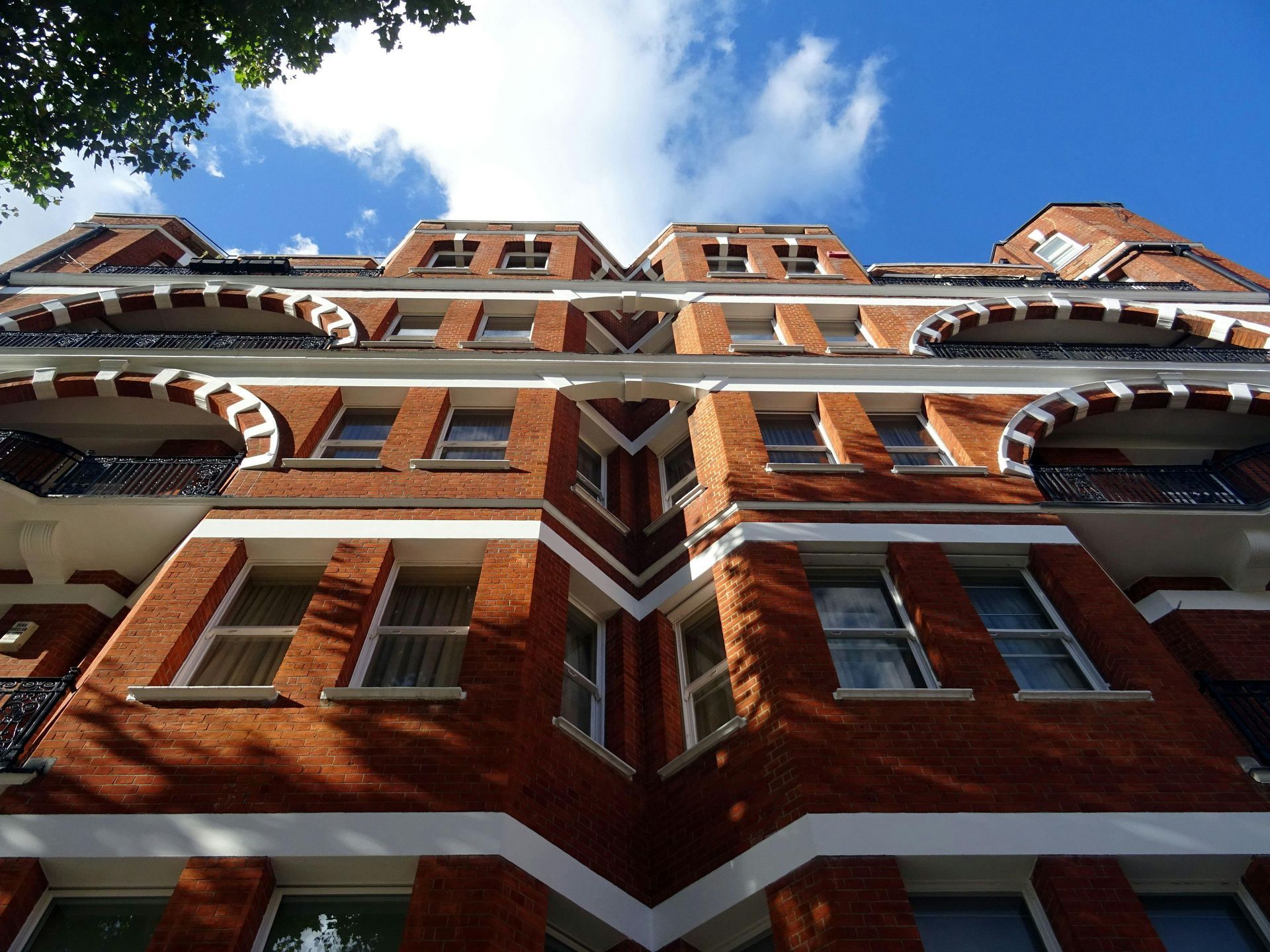 Looking up at a brick building with a blue sky in the background