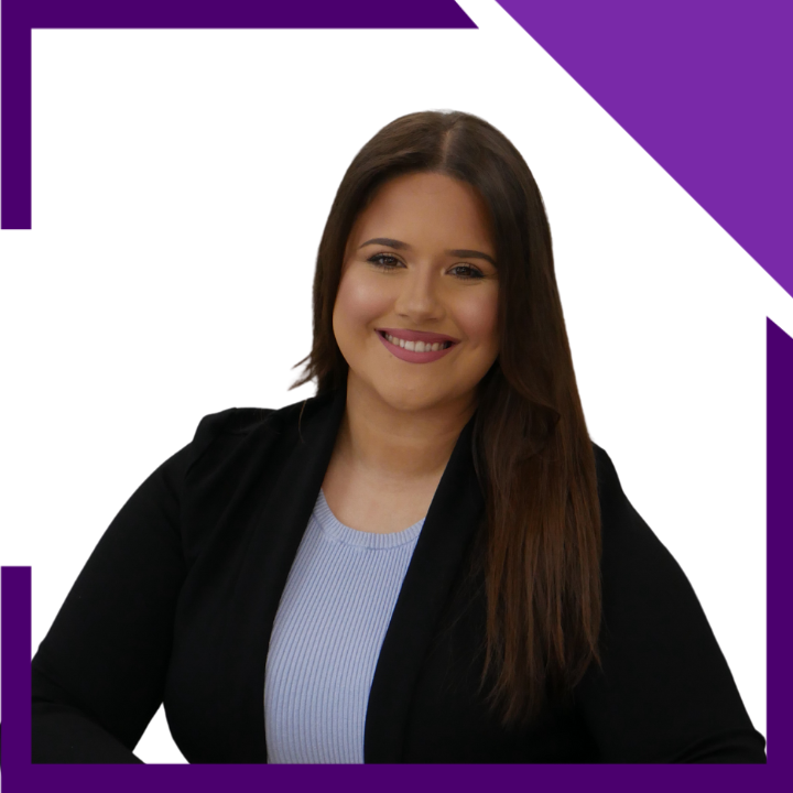 A woman wearing a black jacket and a blue shirt is smiling