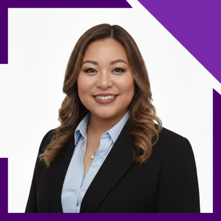 A woman wearing glasses and a black jacket is smiling for the camera.