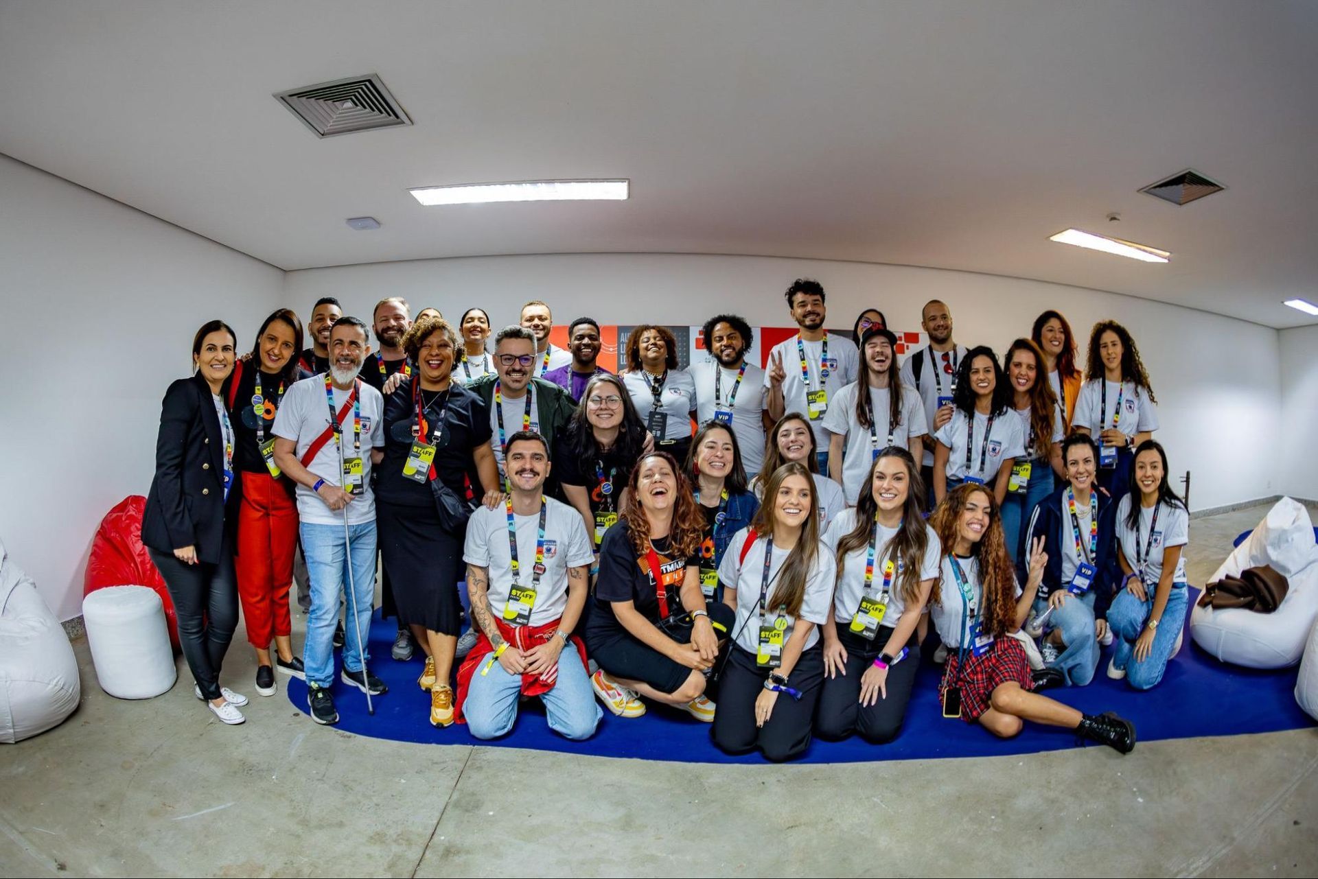 Foto dos 30 HotHeroes abraçados e sorrindo, na sala da Troopers Lounge durante o café da manhã exclusivo para eles no Hotmart FIRE.