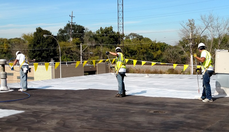 A group of construction workers are working on a roof.