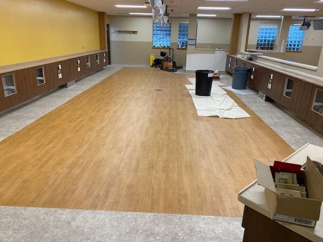 A large room with a wooden floor and a yellow wall