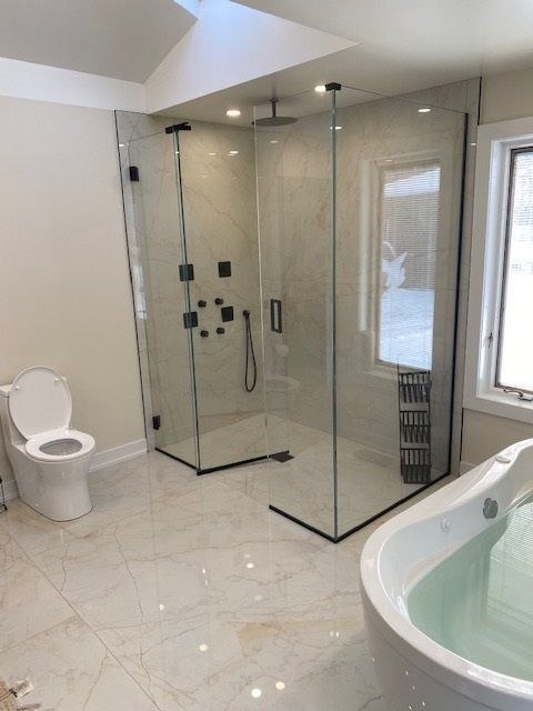 A bathroom with a tub a toilet and a shower