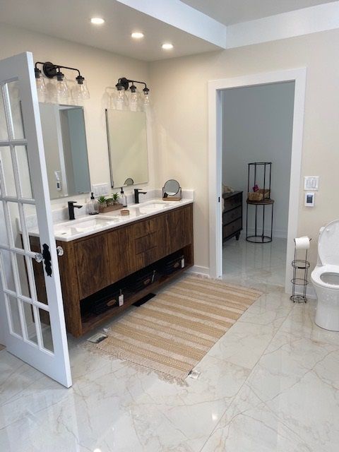 A bathroom with two sinks and a toilet